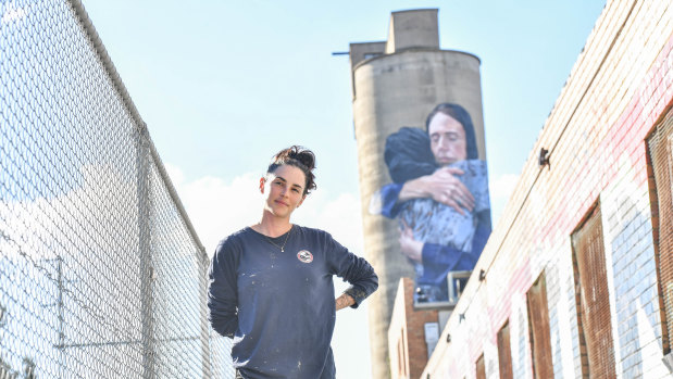 Artist Loretta Lizzo in front of her Brunswick silo mural of Jacinda Ardern.