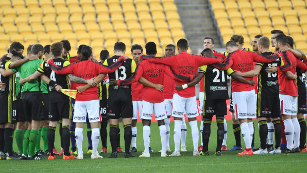 Respects: Phoenix and Wanderers players share a minute's silence for those killed in Friday's terror attack.