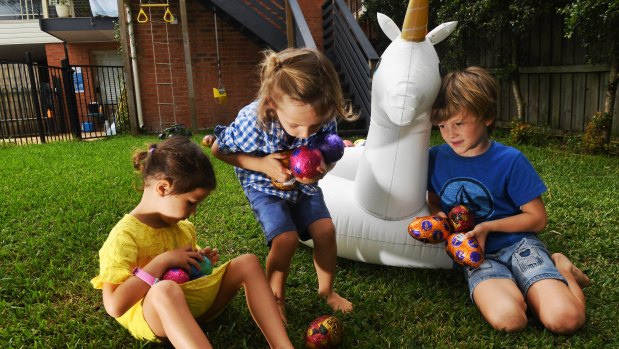 Ollie, Skye and Ash Coutts collect some of the 2 million Easter eggs made by Cadbury each day in the lead-up to Easter.