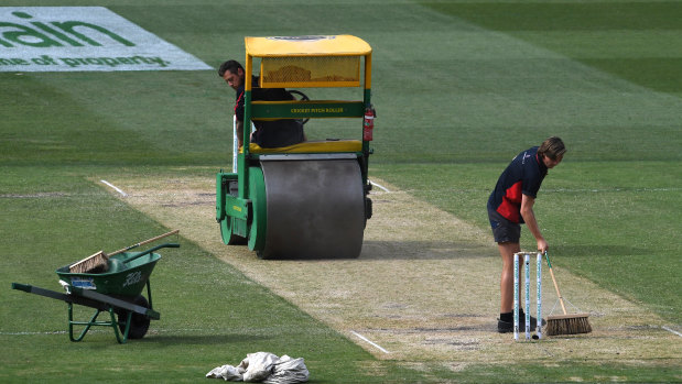 Road ruined: Groundsmen roll the pitch on day two at the MCG.