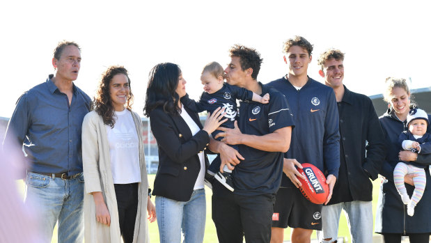 Carlton's Ed Curnow, centre, with his son Will, wife Emily and their extended family at Ikon Park ahead of game 150 this weekend.