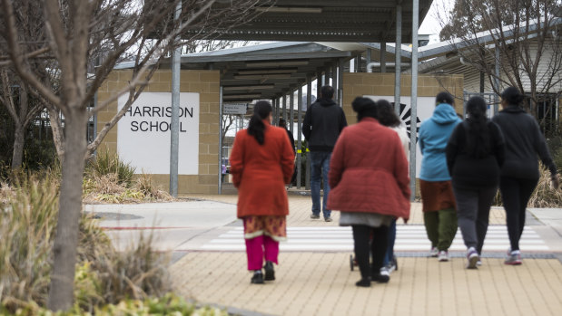 Parents arrive to pick up children from Harrison School on Thursday afternoon, after revelations that asbestos had been found in the schoolyard.
