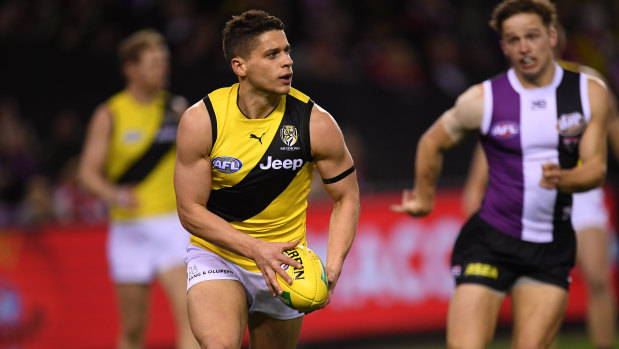 Dion Prestia looks for options as St Kilda's Jack Billings gives chase.