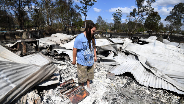 Liam McKenzie inspects the remains of his house, which was destroyed by bushfires.