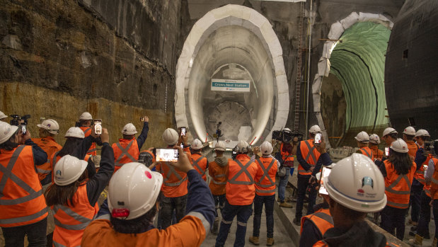 Workers watch the breakthrough of a giant tunnel boring machine at Crows Nest.