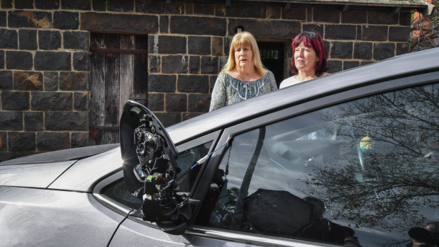 Julie Dougherty, 60, (left) and Leigh Mahady, 62, (right) stand next to the damaged car.