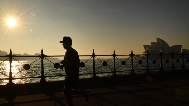 A jogger runs along Sydney Harbour as thick smoke blankets the greater Sydney Basin.