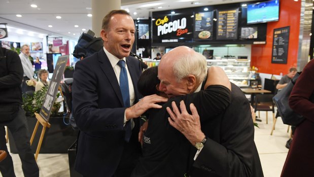 John Howard meets shoppers flanked by Tony Abbott.
