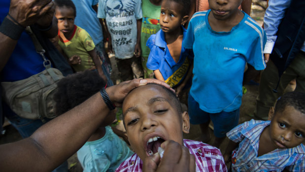 A child in Papua New Guinea receives a polio vaccine. The coronavirus outbreak threatens to reverse decades of progress in alleviating poverty.