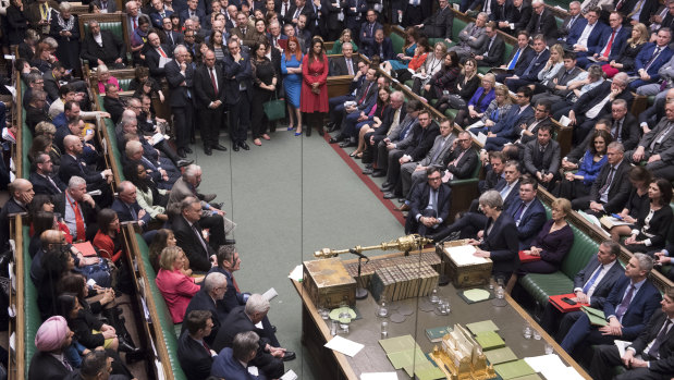 Britain's Prime Minister Theresa May at center right front row, speaks to lawmakers in the House of Commons. 