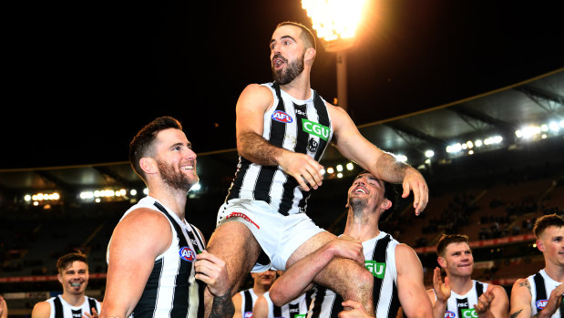 Up in lights: Steele Sidebottom is chaired off by teammates after reaching 200-game milestone.