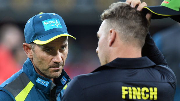 Finch speaks with coach Justin Langer.