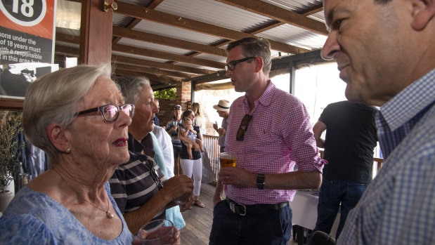 NSW Treasurer Dominic Perrottet, background, meets locals at the Nevertire Pub on a road trip from Dubbo to Bourke.