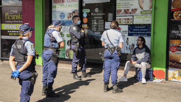 Out in force: Police in western Sydney speaking to a man not wearing a mask.