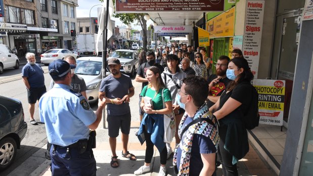 NSW police talk to people in a queue outside a Centrelink office in Sydney as jobs evaporate. 