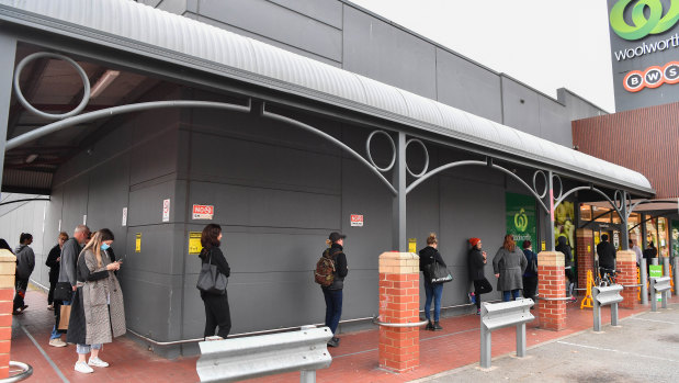 People queue to shop at a Woolworths in Victoria at the height of demand.