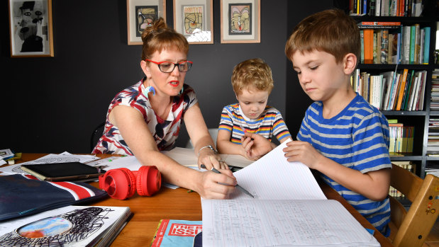 Zoe Collins is seen doing school work with her children Dare, 5, and Douglas, 7, at their home in Brisbane.