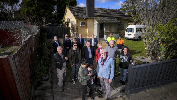 Micaela, front left, with baby daughter Harper, Brother Harry Prout, front right, and some of the 60 volunteers and donors, at one of four renovated Heidelberg West houses.  