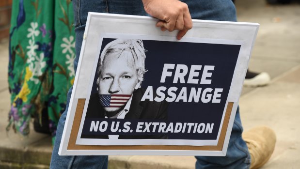 A supporter of Julian Assange and WikiLeaks holds a placard during a snap rally in Sydney on Friday.