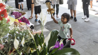 A child lays flowers at Newport Mosque.