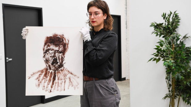 A curator holds Untitled (Concentration Camp) from a series of artworks by Sidney Nolan related to the Holocaust. 