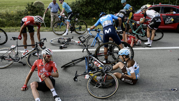France's Axel Domont, right, and Poland's Tomasz Marczynski, left, grimace after crashing in the pack in the last kilometers during the fourth stage of the Tour de France.