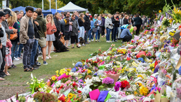 Aftermath: members of the public at a makeshift memorial in the Botanical Gardens in Christchurch.