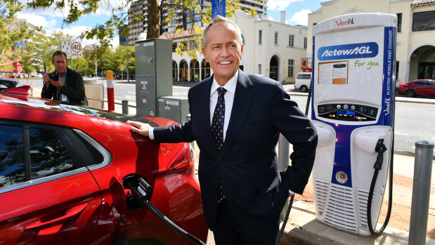 Opposition Leader Bill Shorten charges an electric car after launching Labor's Climate Change Action Plan in Canberra on Monday.