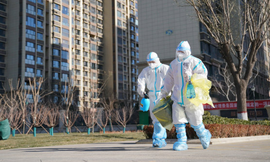 Workers carry a container of coronavirus test samples outside of a residential neighbourhood in Shijiazhuang in northern China's Hebei Province on Friday. 
