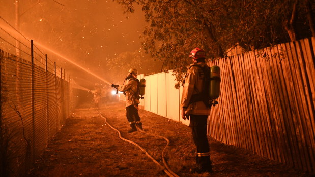 Firefighters fight flames close to homes in Wattle Grove on Saturday. 