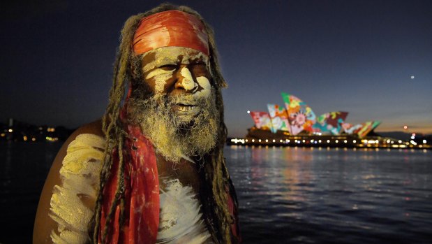 Koomurri performer Les Daniels in front of a projection of artwork by Pitjanjara artist David Miller on the sails of the Opera House on Australia Day.