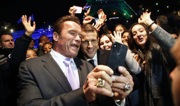Arnold Schwarzenegger takes a selfie with French President Emmanuel Macron.