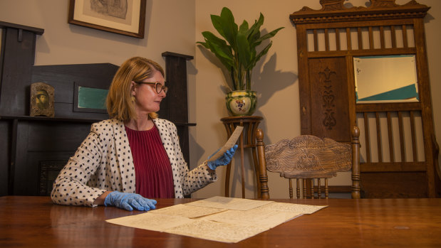 Curator Elise Edmonds holding some letters from the Burrowes' children in a recreation of the Burrowes' family home in Rooty Hill. 