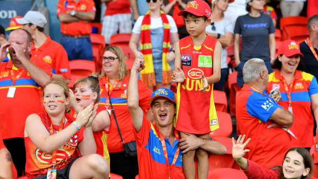 Good as gold: Suns fans cheer on their team at Metricon Stadium.