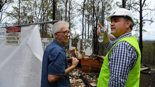 Peter Hassell (left) at the site of his home that was destroyed by fire in November with Deputy Premier John Barilaro. 
