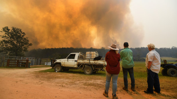 Locals watch smoke from a large bushfire outside Nana Glen, near Coffs Harbour.