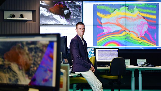 Senior forecaster Steven McGibbony, with a "spaghetti model" of high and low pressure systems behind.