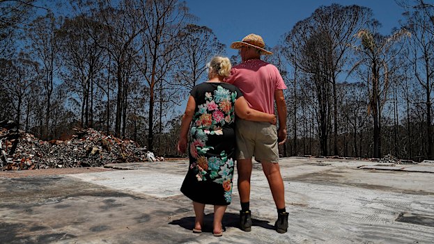 The Duncans stand on the slab of their Rainbow Flat home and look at what they have left.