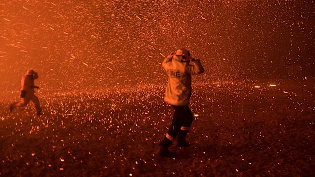 Firefighters run for safety as the Green Wattle Creek fire exploded from the bush in Orangeville on December 5. 