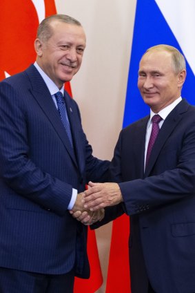 Russian President Vladimir Putin, right, and Turkish President Recep Tayyip Erdogan shake hands after their joint news conference.