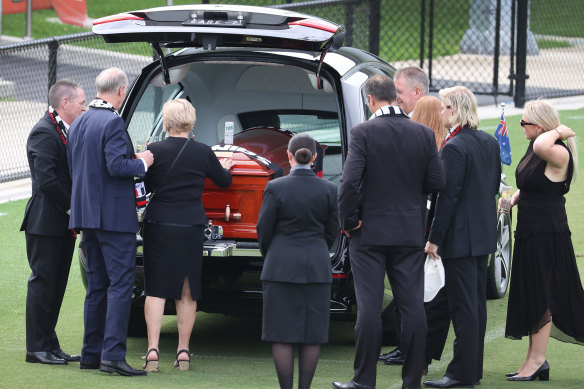 Warne’s mother, Brigitte, touches her son’s coffin.