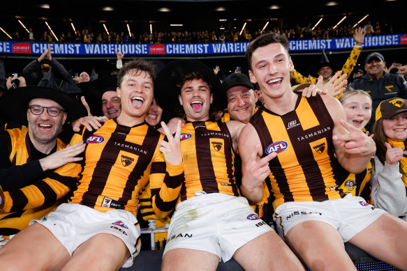 Jack Ginnivan, Nick Watson and Connor Macdonald of the Hawks pose for a photo after their win over the Western Bulldogs.