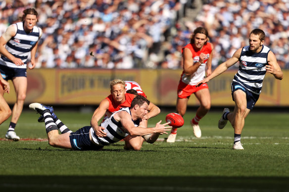 Patrick Dangerfield is tackled by Isaac Heeney.