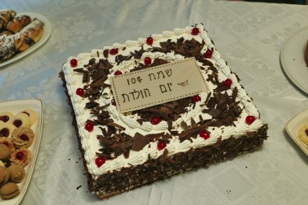 Aurbach’s birthday cake inscribed with “Happy 104th Birthday” in Hebrew.