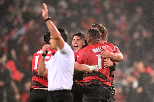 James O’Connor is swamped by Crusaders teammates after his winning kick.