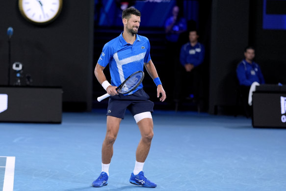 Djokovic winces after hurting his leg.