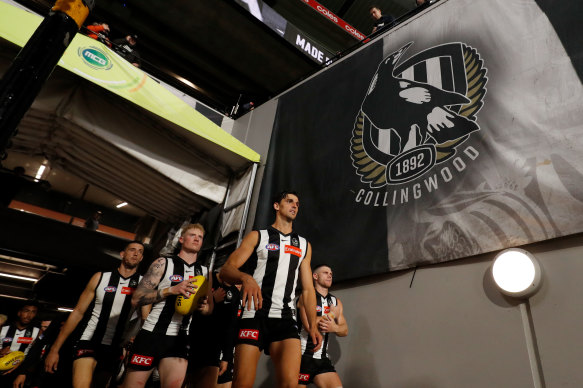 Magpies players emerge from the MCG race for a game last year.