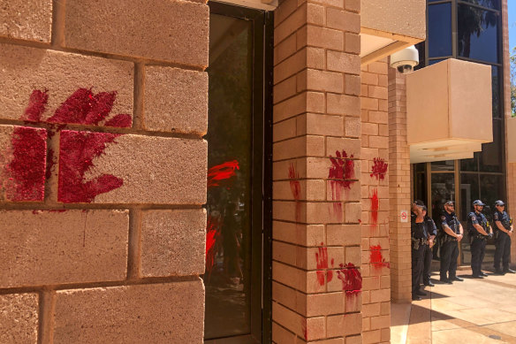 Protesters leave red hand prints on the Alice Springs police station.
