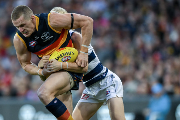 Reilly O’Brien of the Crows tackled by Oliver Dempsey of the Cats.