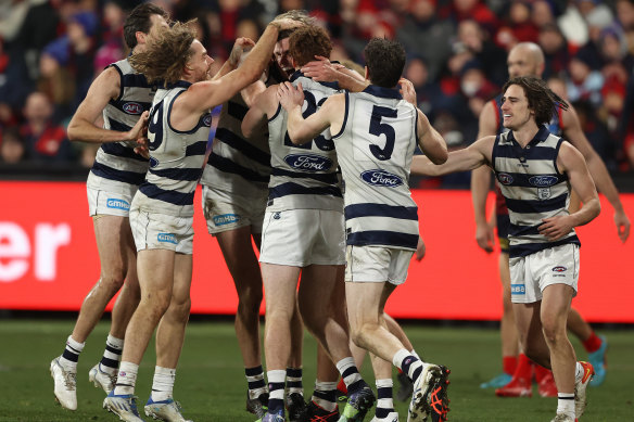 Tom Hawkins is mobbed by teammates after kicking a goal.